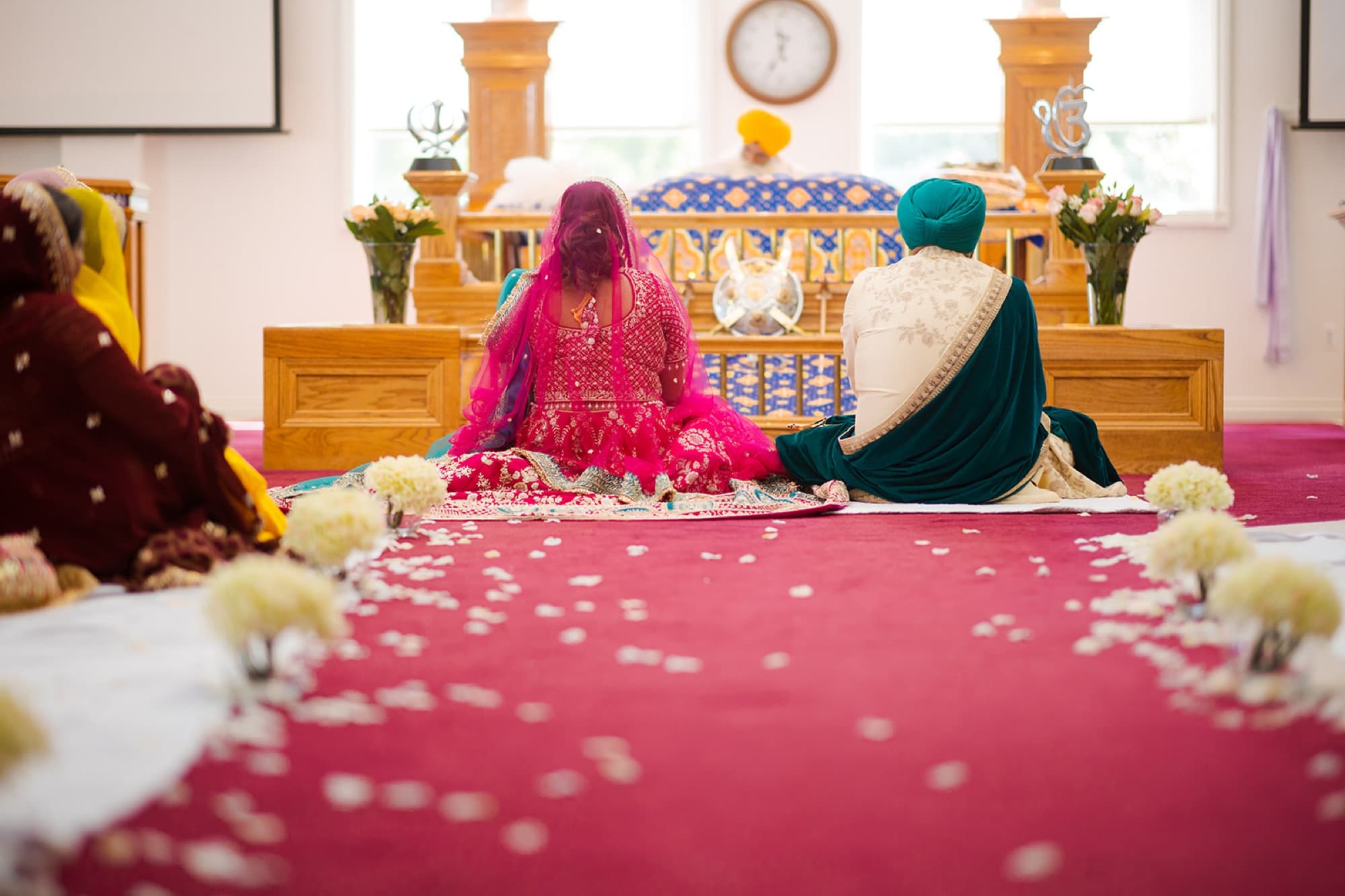 Anand karaj ceremony at the gurdwara with petals on the red carpet, Toronto Sikh wedding