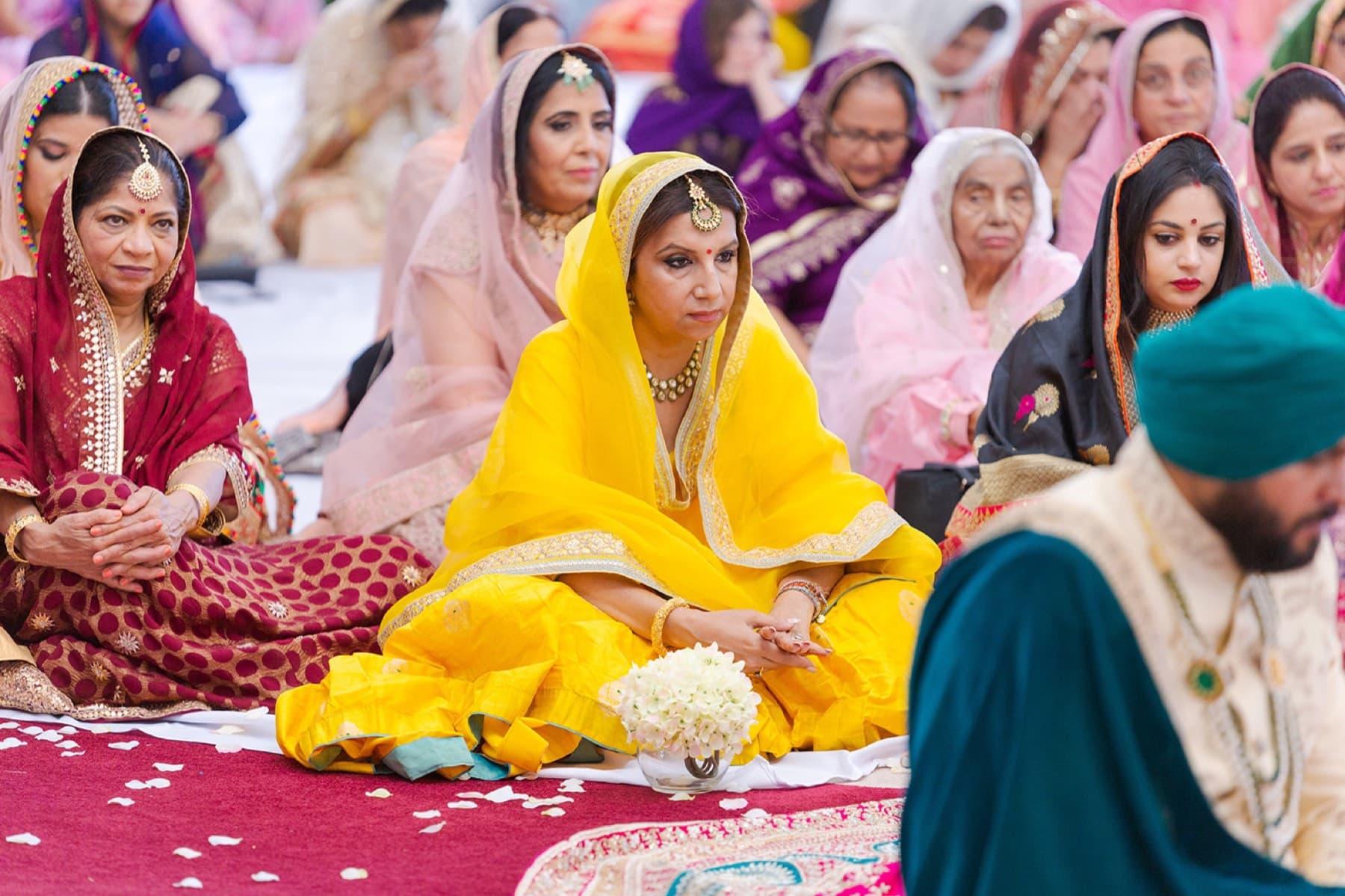 Bride seated among petals during the ceremony, Toronto