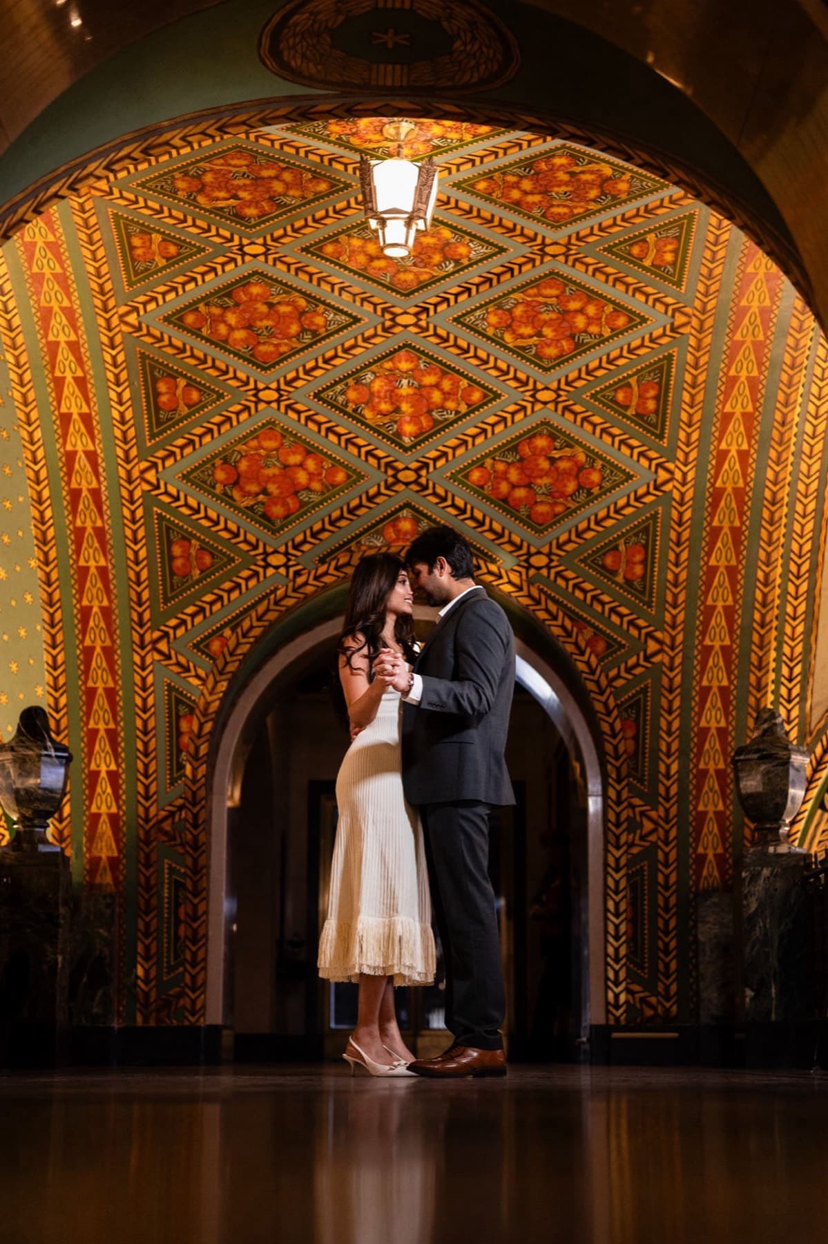 Couple beneath an ornate golden arch, engagement session, Toronto