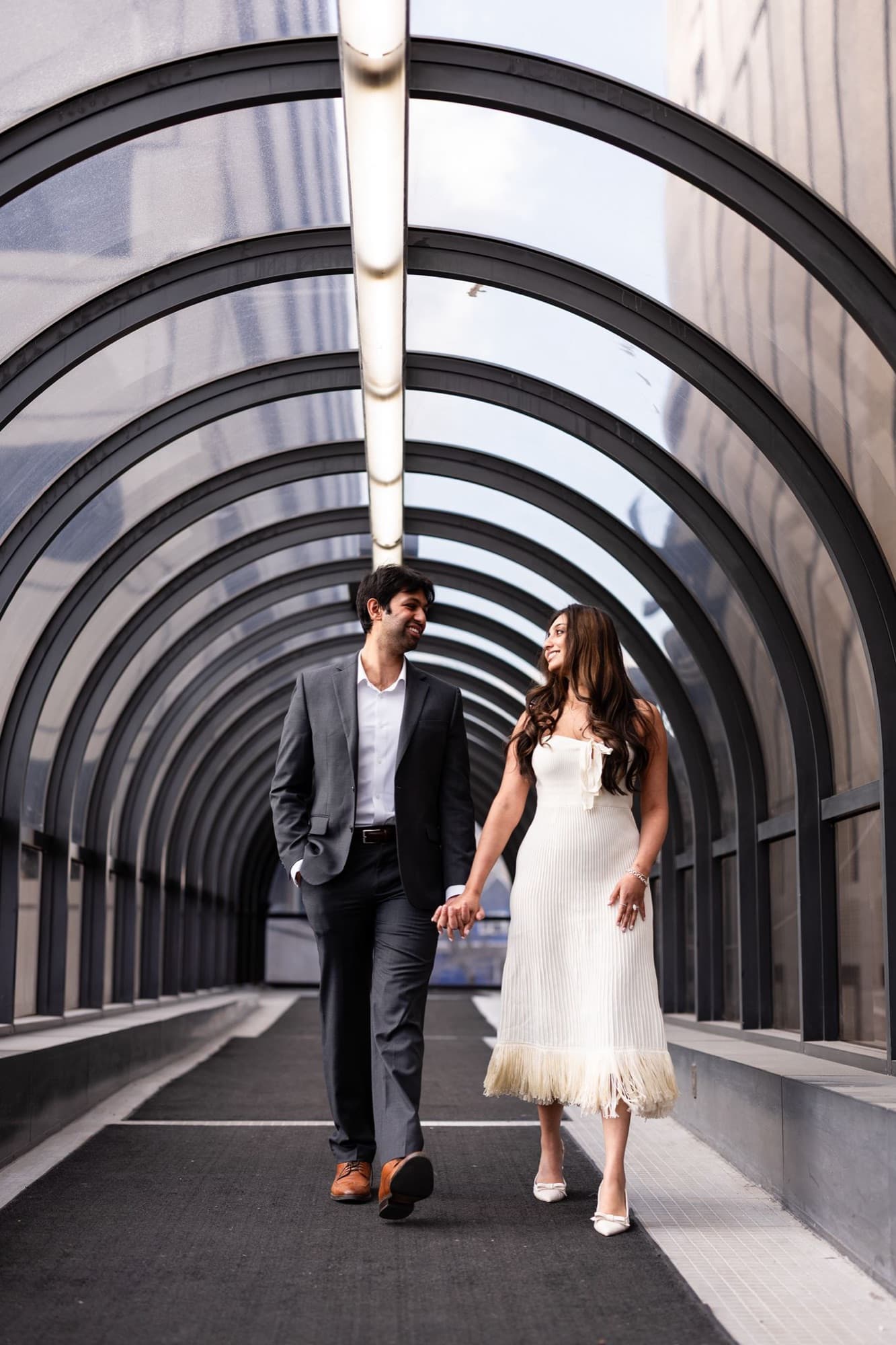 Couple walking the arched tunnel hand in hand, Toronto engagement
