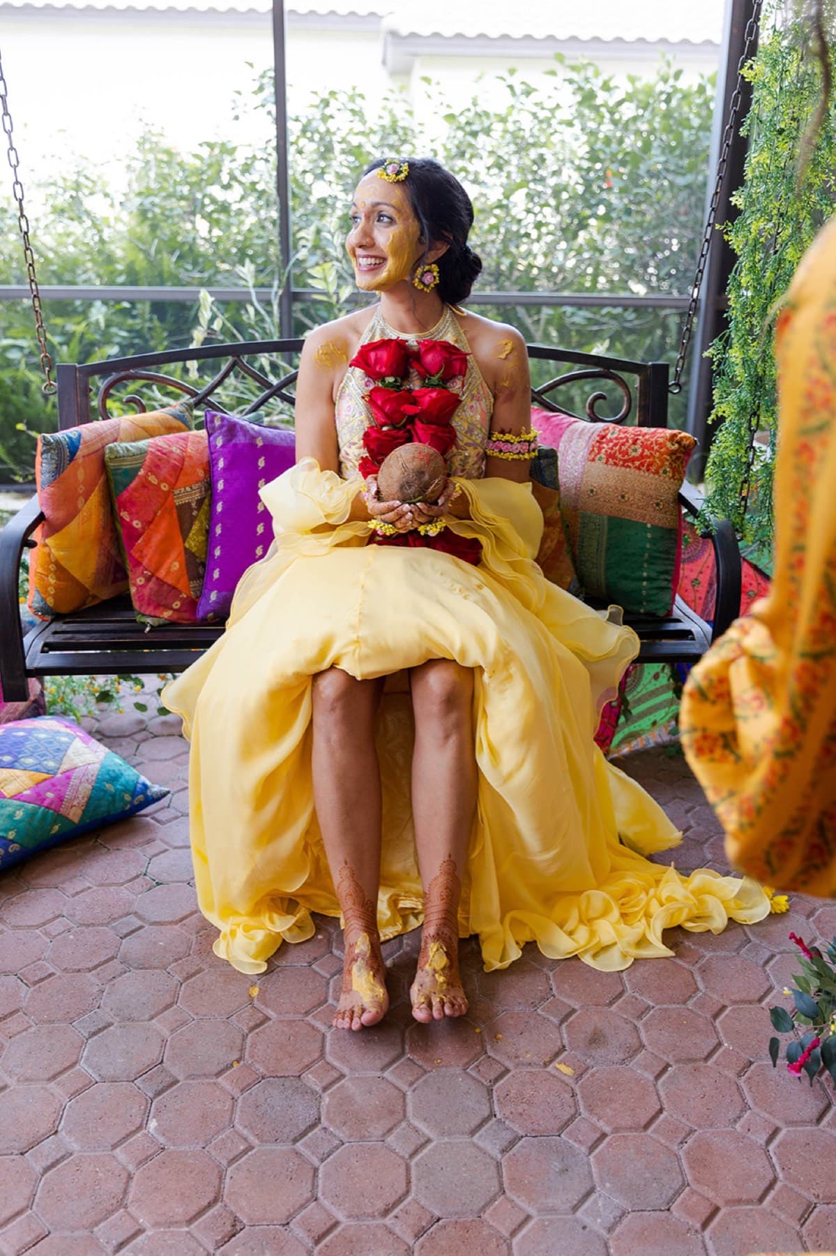 Rose petals shower the bride on the swing during her haldi, Toronto