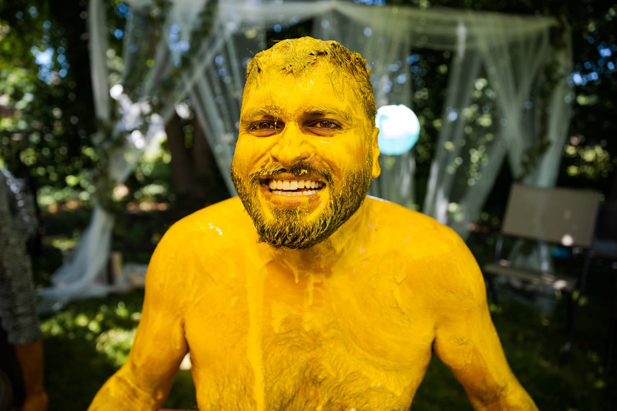 Groom covered in turmeric laughing at his haldi ceremony, GTA