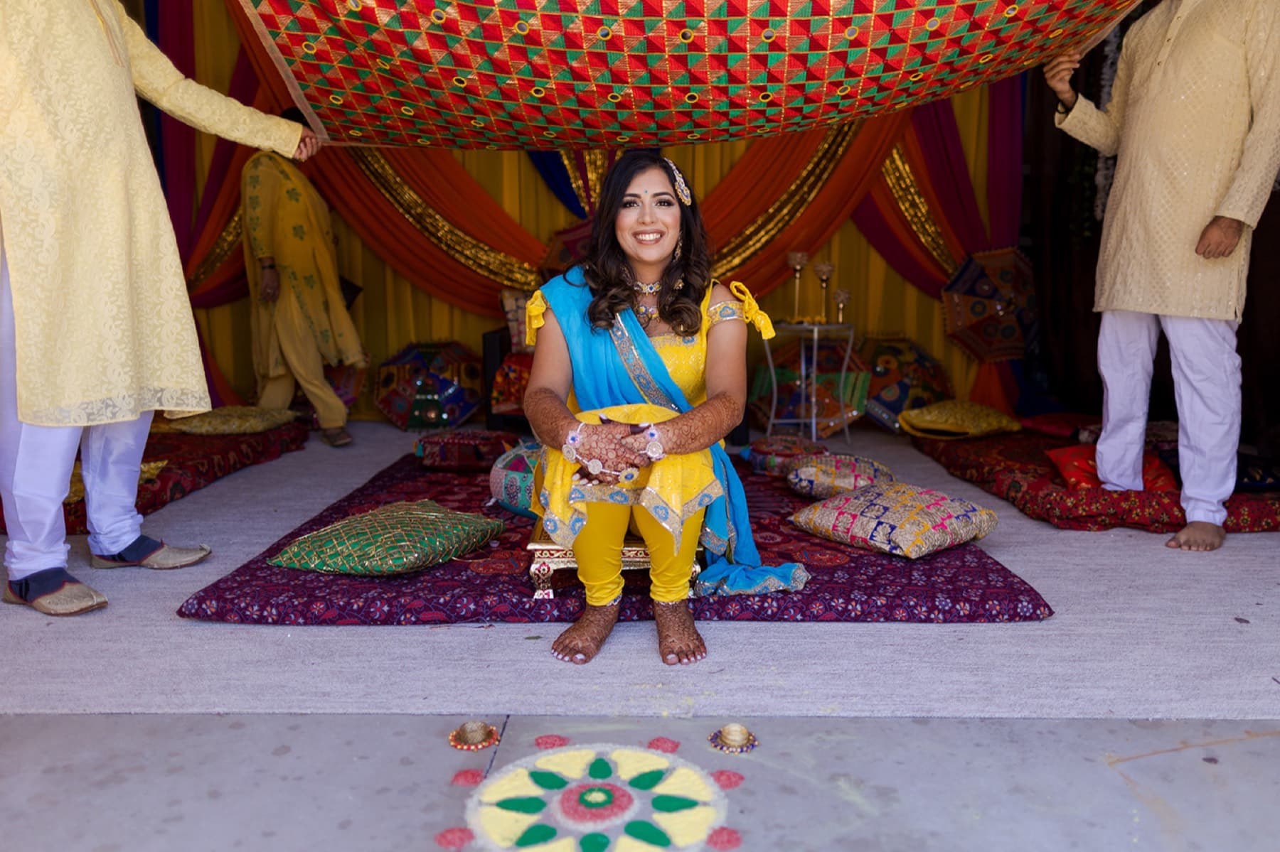 Bride beneath the haldi canopy with rangoli, Toronto