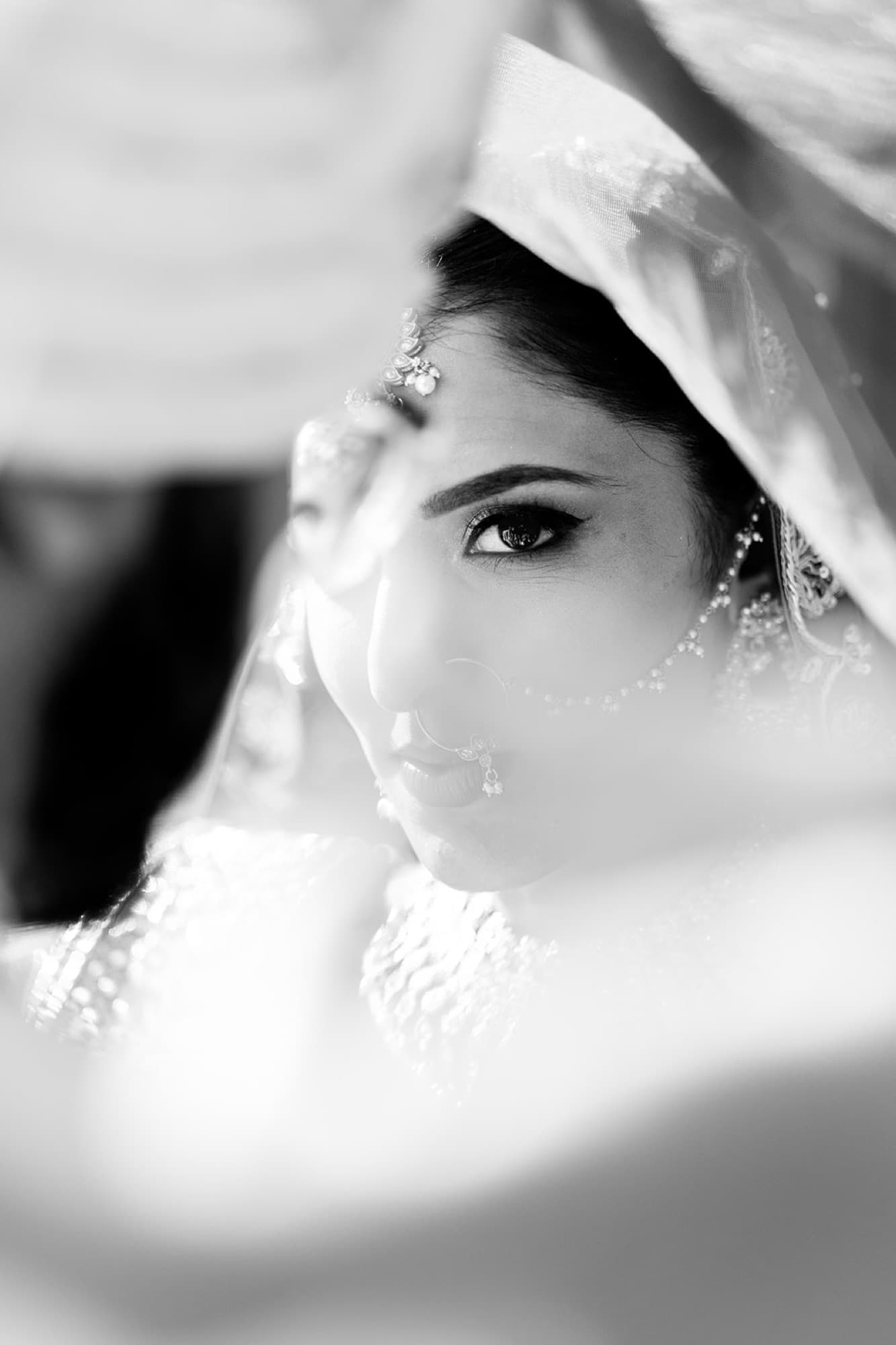 Bride glowing behind her red dupatta before the ceremony, Toronto wedding photography