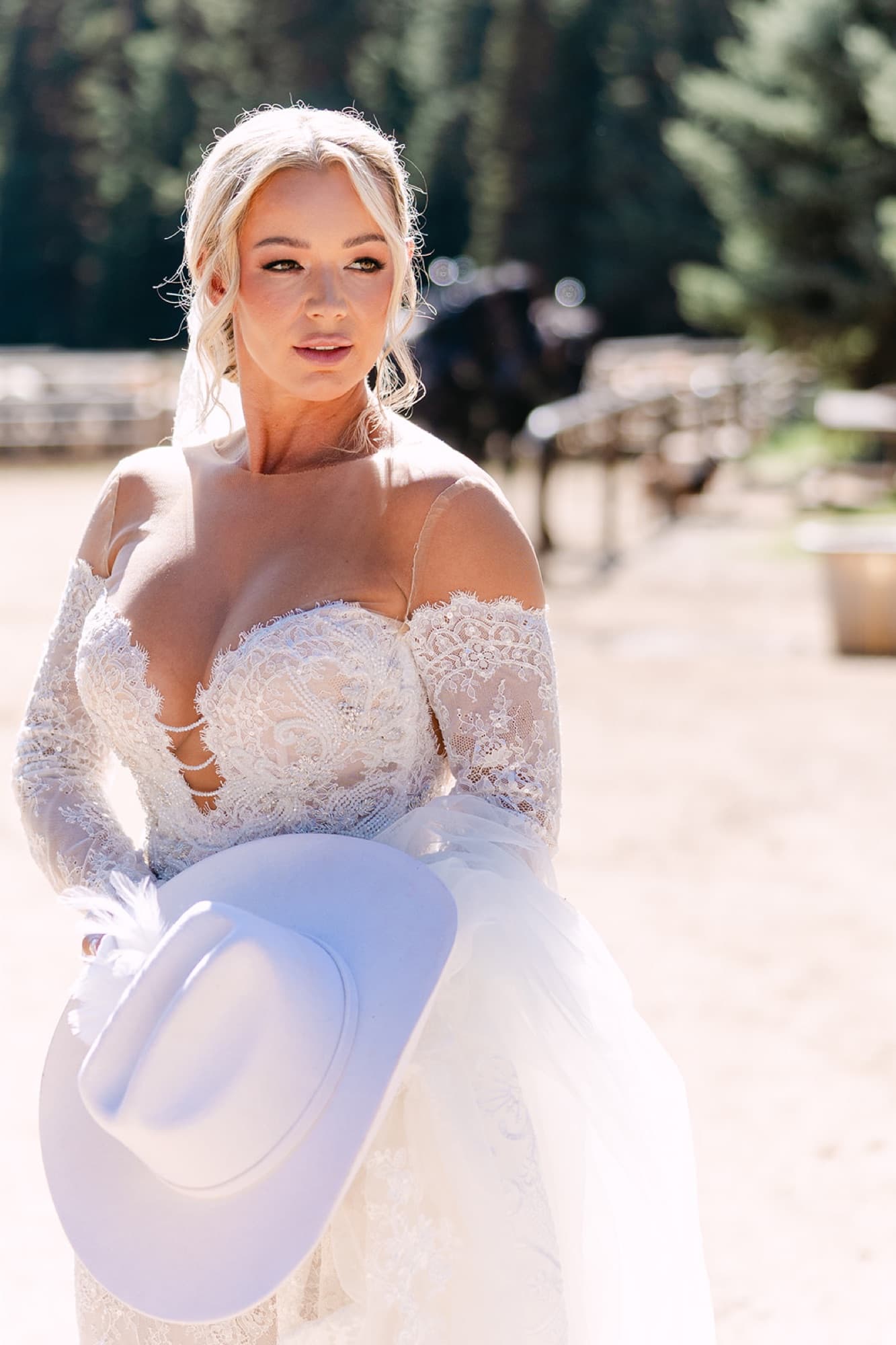 Bride with her hat at a ranch wedding, editorial portrait