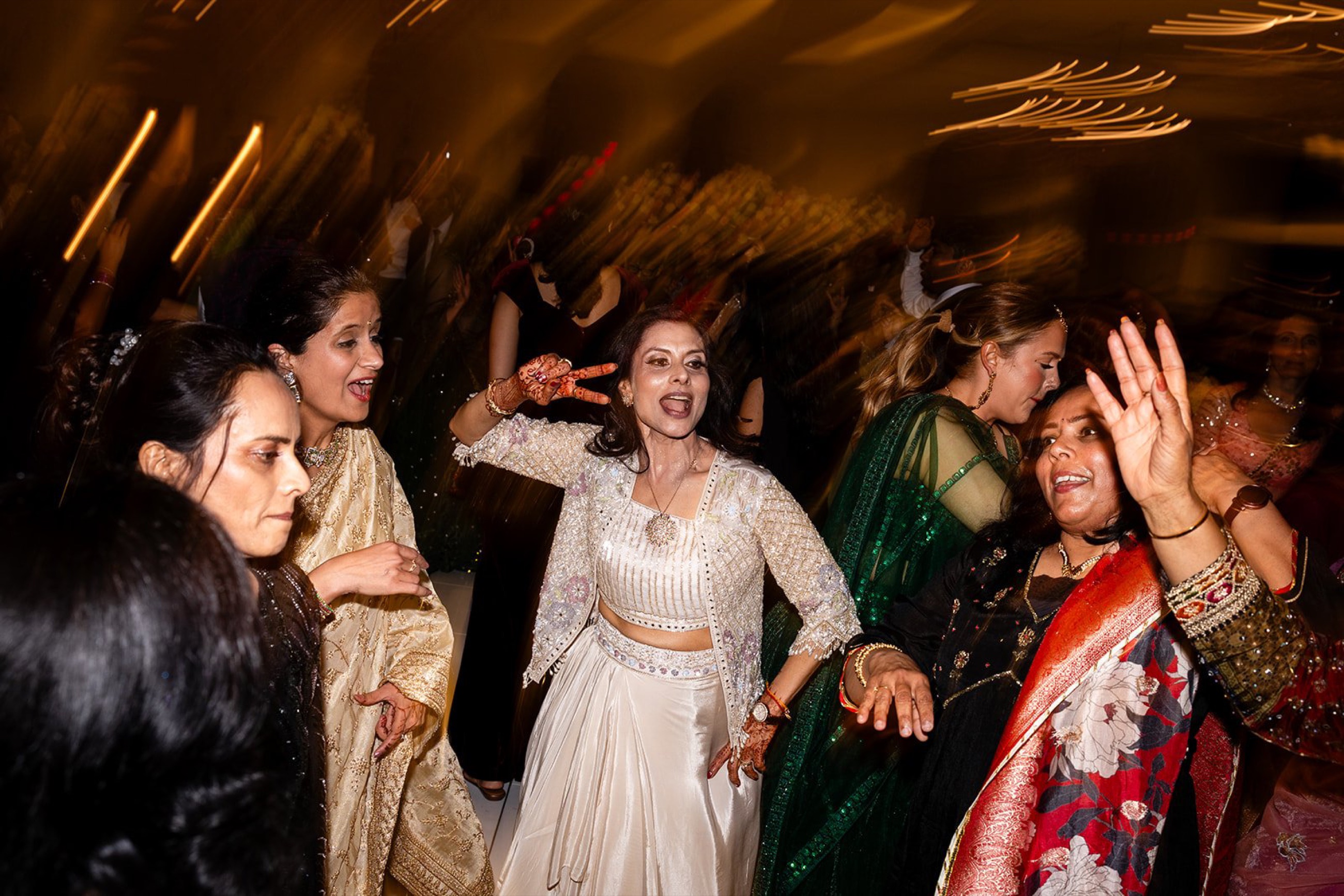 Guests dance under golden lights at a sangeet night reception, Toronto wedding films