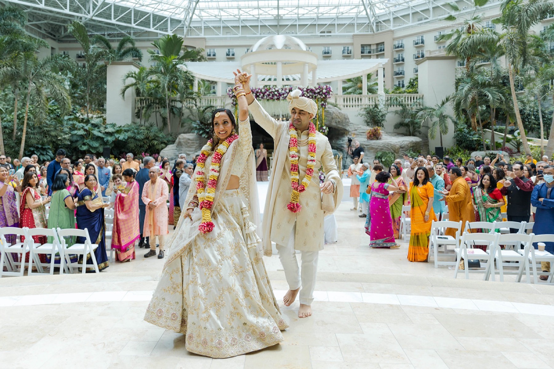 Couple in garlands celebrating the recessional, Toronto South Asian wedding